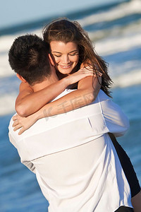 一对年轻的男女在海滩上开心地玩耍和拥抱，就像一对浪漫的情侣
