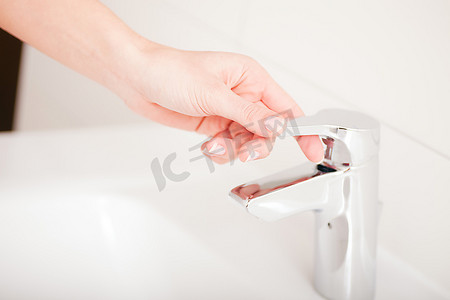 女人洗手后关上水龙头(只露出手)