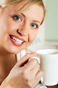 早上，美丽的女人喝着一杯热咖啡