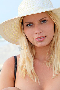 海滩上戴着帽子的金发美女特写