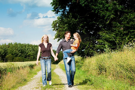 幸福的家庭(母亲、父亲和孩子)在大自然中散步