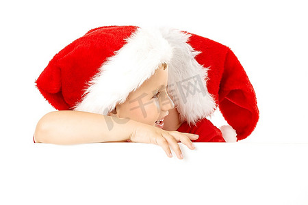 一个戴着圣诞老人帽子的小男孩在空白的横幅上窃窃私语，与世隔绝