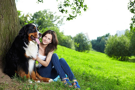 一个漂亮的女孩和一只狗在公园
