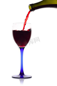 红酒从绿色的瓶子流到玻璃杯里。白葡萄酒