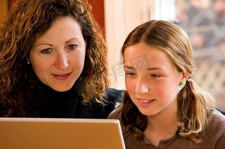 妈妈和女儿在电脑笔记本电脑上工作。