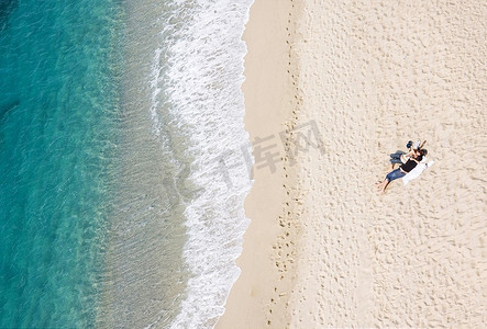 年轻夫妇在热带海滩休息的景色，大量的文案空间
