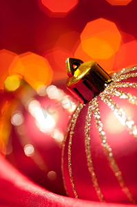红色丝绸上的圣诞装饰球与背景模糊的灯光映衬，浅浅的DOF