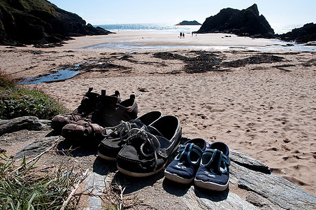侧面鞋子摄影照片_在海滩边等待的鞋子