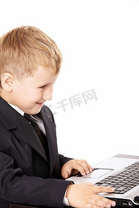 穿着西装的小男孩拿着笔记本电脑