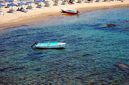 小小的沙滩，有摩托艇、沙滩椅和雨伞的小港口。晴朗的一天。希腊罗得岛。