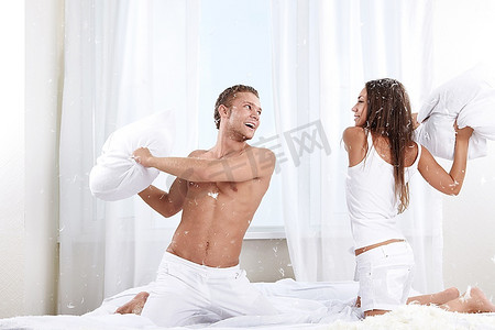 年轻夫妇战斗枕头在卧室