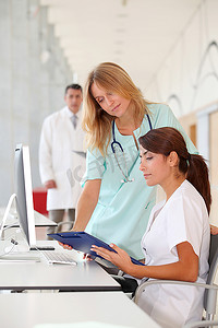 护士与实习生在电脑前工作