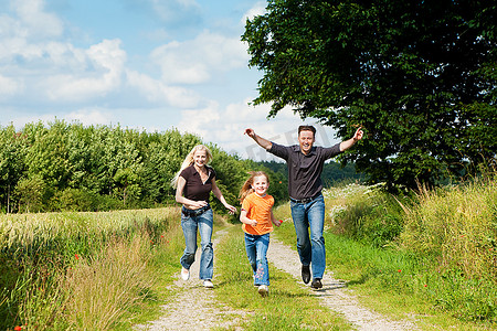 愉快的家庭（母亲，父亲和孩子）有一次散步在自然玩标签