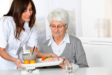 老人健康摄影照片_养老院美女护士为老太太端餐盘