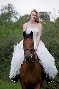 穿着婚纱的女人骑在马上。