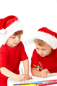 两个戴着圣诞老人帽子的小男孩在床单上画画