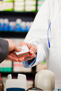 药剂师和顾客在药房；顾客用信用卡付款；从两只手都能看到