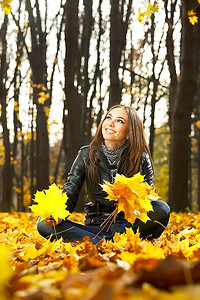 秋天公园里的美女在收集树叶