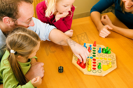 一家人一起玩棋盘游戏，玩得很开心