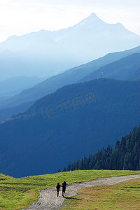 主播马上回来摄影照片_徒步旅行者走在山路上，勃朗峰谷，西阿尔卑斯山，意大利。