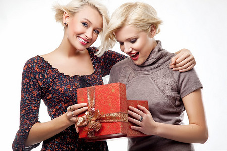 两个微笑的金发美女拿着圣诞礼物