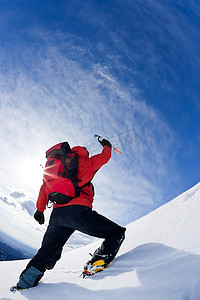 登月摄影照片_登山者登上白雪皑皑的山峰。垂直框架。