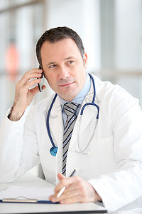 诊所电话摄影照片_英俊的医生在电话里交谈的肖像