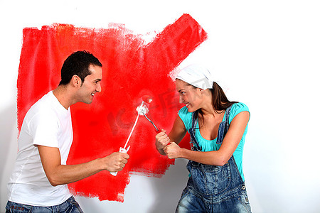 一对夫妇在油漆他们的新房子时玩得很开心