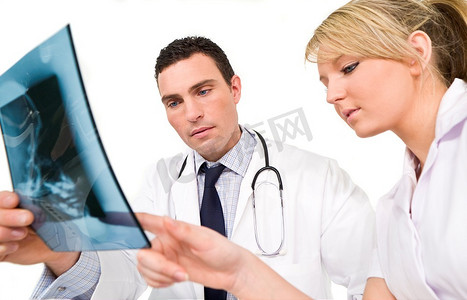x光头骨摄影照片_一位男医生和他的女护理同事正在检查一个人类头骨的X光片。