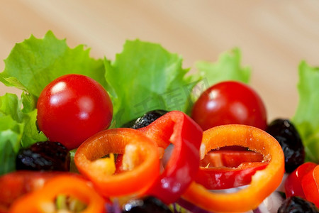 宏观照片新鲜生菜，番茄，辣椒，黑橄榄，红洋葱和红卷心菜沙拉
