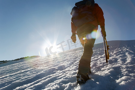 日落时在冰川上行走的登山者