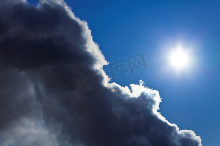 这张照片显示了太阳和蓝天从暴风雨云后面出现。