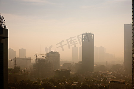 城市摄影照片_污染严重的城市日出时的雾霾穹顶和尘埃--在这种情况下，印度尼西亚雅加达