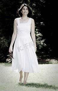 一位年轻的拉丁女孩的垂直肖像，黑发，穿着白色衣服