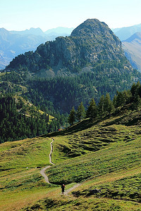 徒步旅行者走在意大利西部阿尔卑斯山的勃朗峰山谷的山路上。