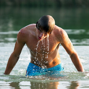 非常有运动天赋的游泳者从水中出来，水滴在美丽的光线下顺着身体流下来，现在是夏天
