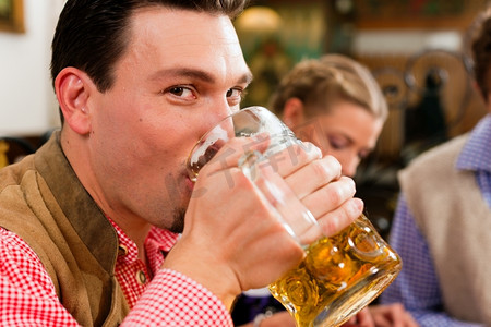 巴伐利亚州的客栈或酒吧--穿着传统Tracht的男人喝着啤酒
