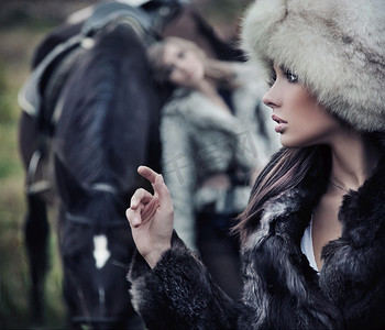 两个浪漫的女模特和一匹马摆姿势合照人物特写