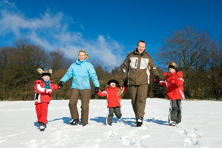 子代摄影照片_活跃的家庭在雪地里冬季散步