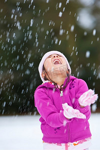 一个年轻漂亮的女孩在雪地里玩得很开心