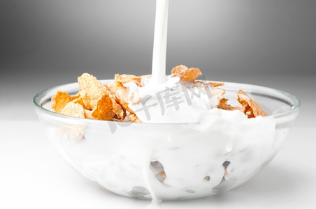 制氢能源板块摄影照片_牛奶流到装有玉米片的碗里