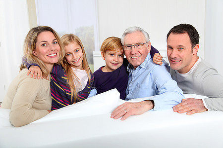 肖像幸福的家庭坐在沙发上在家里