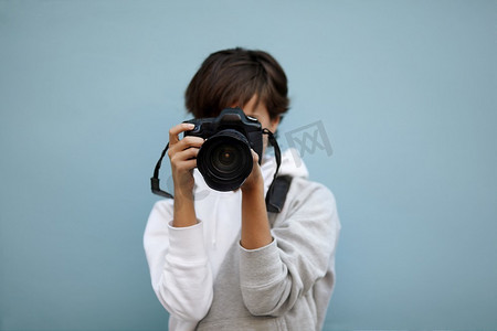配备专业相机的年轻女性，选择性地聚焦在镜头最近的部分