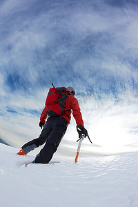 登山者登上一座雪山的顶峰。垂直框架。