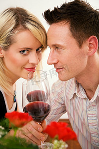 年轻情侣浪漫晚餐：红酒碰杯