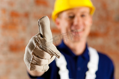 友好可靠的建筑工人竖起大拇指，专注于大拇指