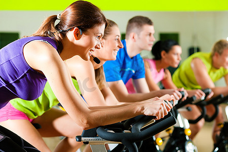 五人一组--男人和女人--在健身房或健身俱乐部旋转，锻炼他们的腿，进行有氧运动训练