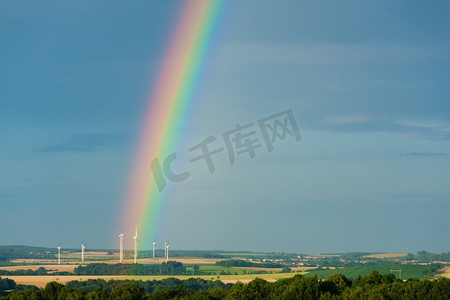 夏天，美丽风景中的彩虹和电动风车