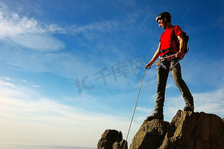 攀岩/登山者在攀登的顶峰，沐浴在灿烂的阳光下。意大利西阿尔卑斯山。