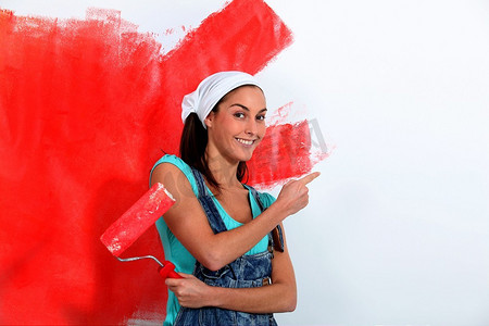 一名年轻女子把房子的墙壁漆成红色